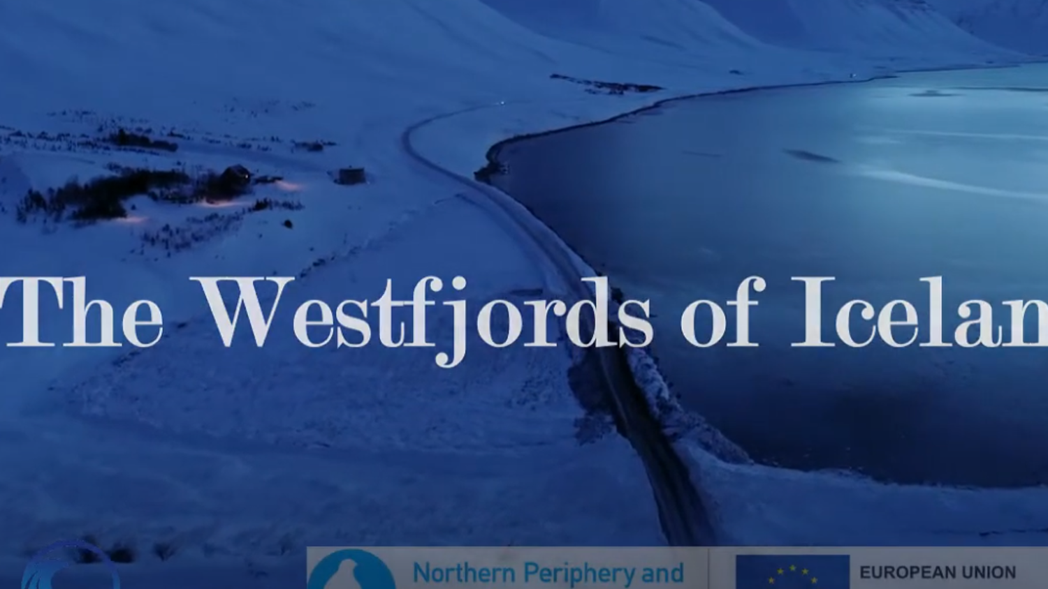 A snowy landscape of the Westfjords in Iceland is shown, with a winding road beside a large, calm body of water under a twilight sky. Logos of the European Union and other organizations are displayed at the bottom.
