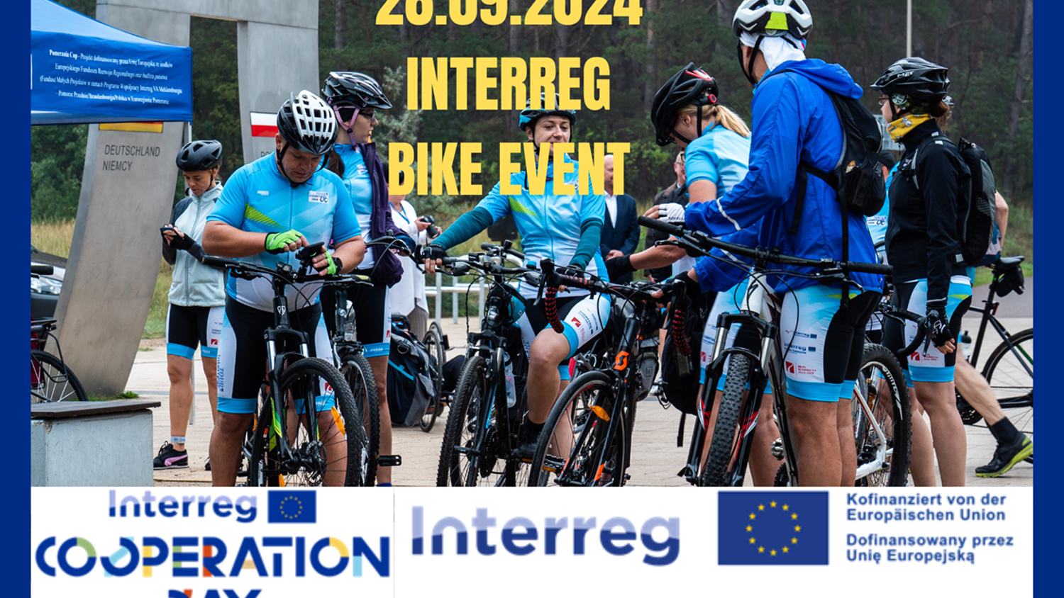 A group of cyclists in blue and teal gear gather with their bikes at an outdoor event. Text reads: "28.09.2024 INTERREG BIKE EVENT." Logos and sponsors are displayed at the bottom, including "Interreg Cooperation Day.